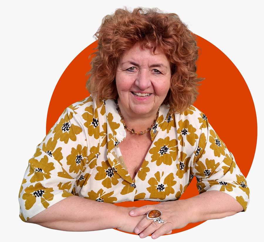 Pamela Anna Guggenheim stützt sich auf einen Fels und lächelt in die Kamera.